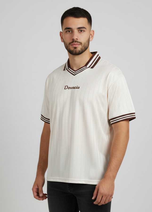 Man wearing a white sports jersey with a logo on a plain background