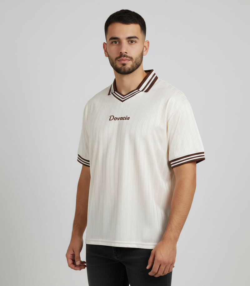 Man wearing a white sports jersey with a logo on a plain background