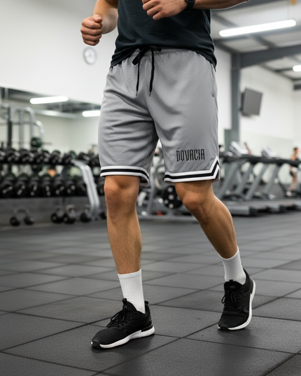 Person wearing gray athletic shorts with 'BOVACIA' branding in a gym setting.