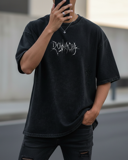 Person wearing a black t-shirt with 'Dovация' logo, holding a phone.
