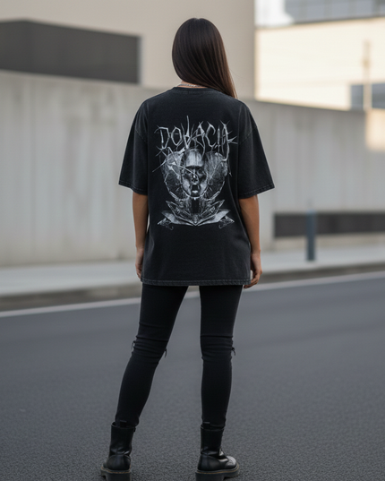 Person wearing a black t-shirt with a graphic design on the back, standing on a street.