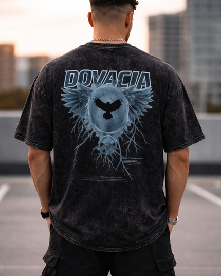 Person wearing a black t-shirt with 'DONACIA' branding and design on the back, standing on a rooftop.