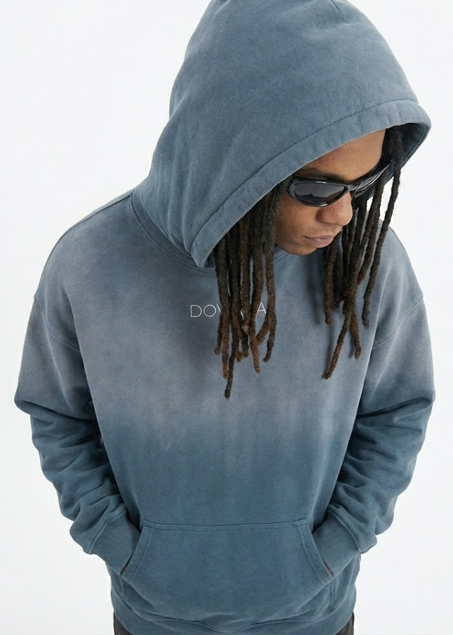 Person wearing a blue hoodie with a brand logo on a white background