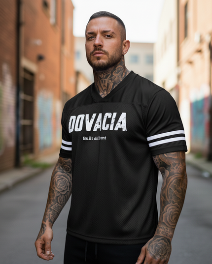 Man wearing a black 'DOVACIA' t-shirt with white text in an urban setting