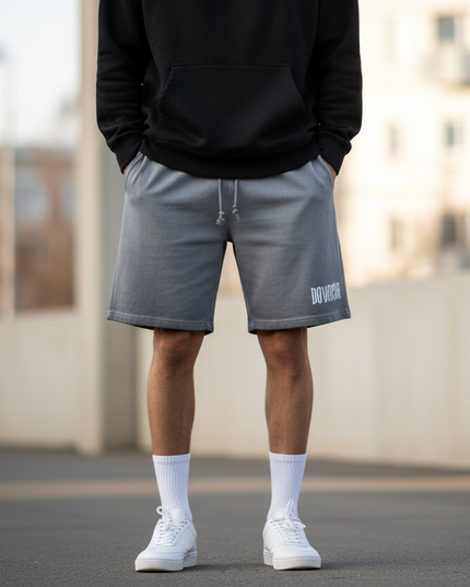 Person wearing a black hoodie and gray shorts with a blurred background