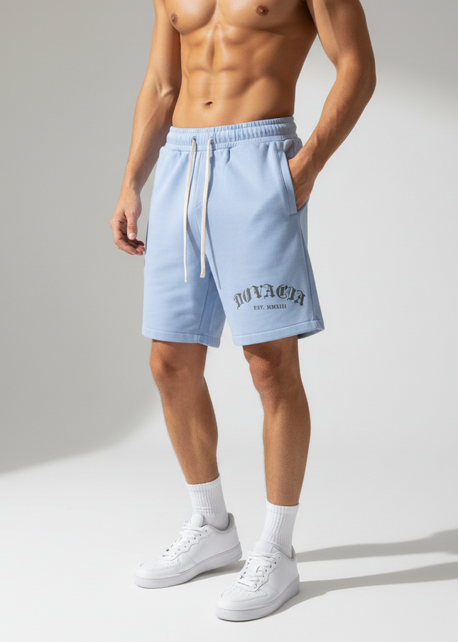 Person wearing light blue shorts with a brand logo on a neutral background