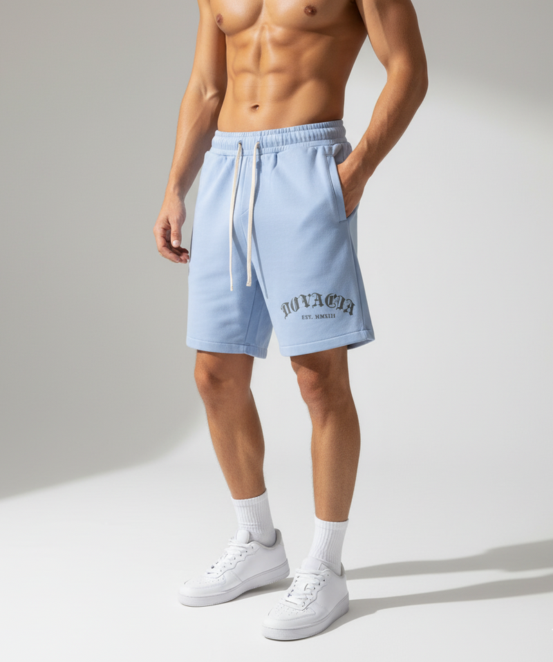 Person wearing light blue shorts with a brand logo on a neutral background