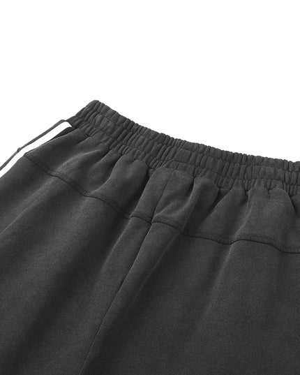 Close-up of dark gray sweatpants with an elastic waistband on a white background