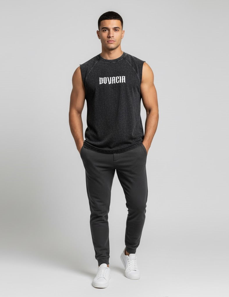 Man wearing a black sleeveless shirt with 'BOVACIA' logo and black pants on a white background